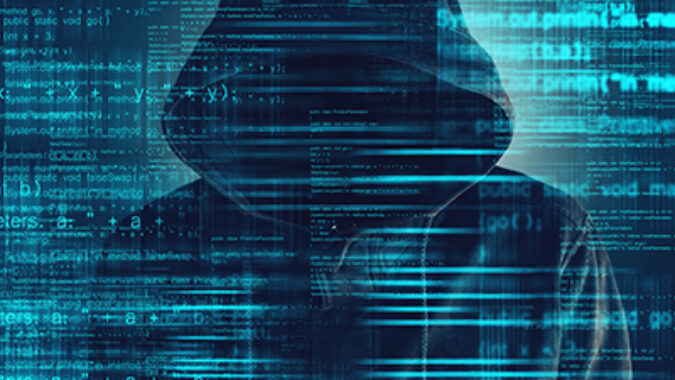 image of Cybersecurity, computer hacker with hoodie and obscured face, computer code overlaying image