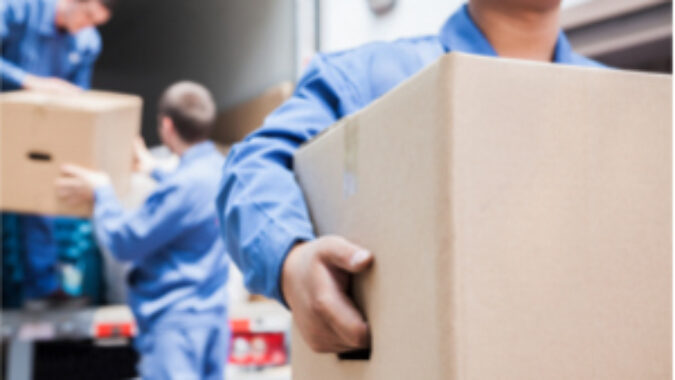 Workers unloading boxes from back of a truck