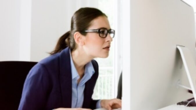 Woman squinting at computer screen