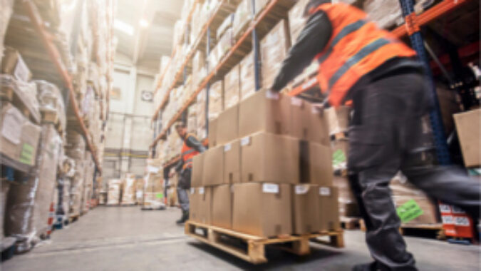 Guy pushing a pallet dolly in a warehouse